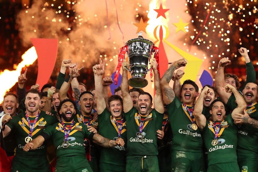 A man lifts a trophy after winning a rugby league match