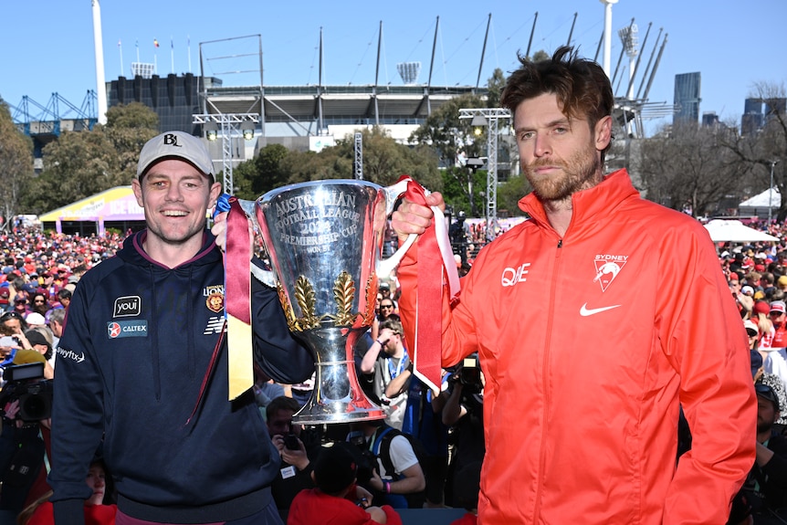 Captains Lachie Neale and Dane Rampe hold the AFL premiership cup during the grand final parade.