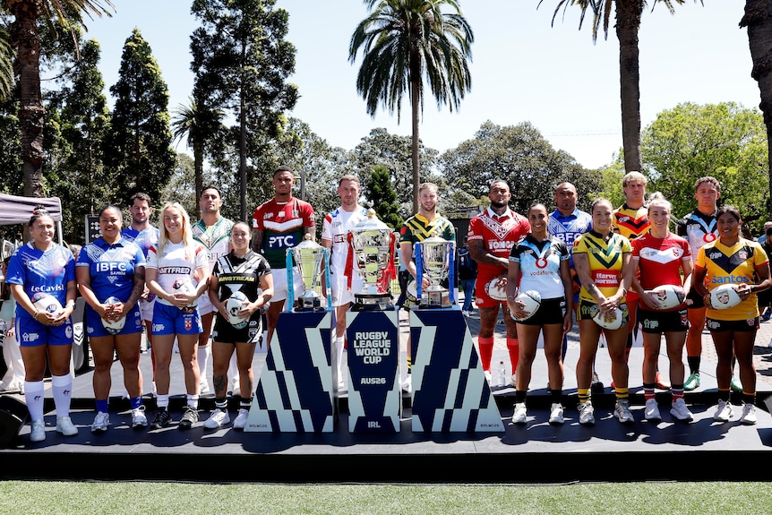 Male and female rugby league players standing on a platform