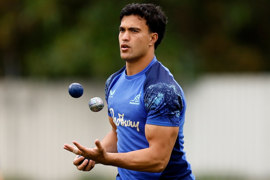 Joseph-Aukuso Suaalii juggles rugby balls at a Wallabies training session.